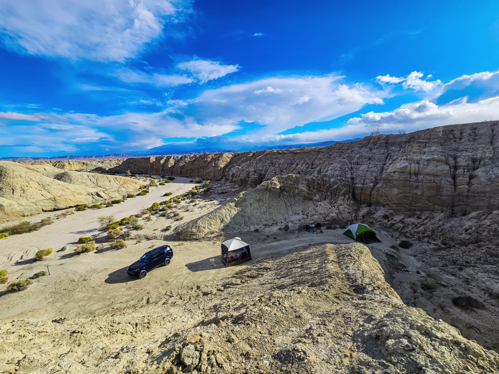 Dispersed camping setup in Anza-Borrego Desert State Park badlands with SUV and two tents