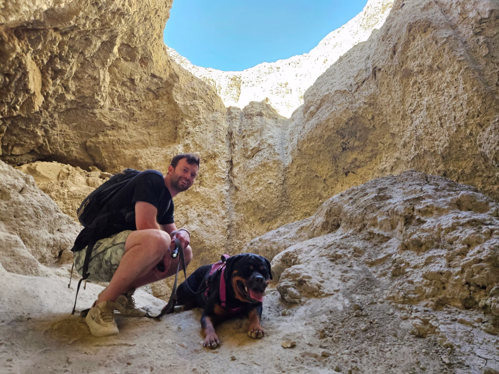 Hiker with dog inside Wild Mud Cave slot canyon Anza-Borrego